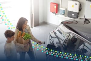 Woman holding groceries plugging in her elecric car in a garage